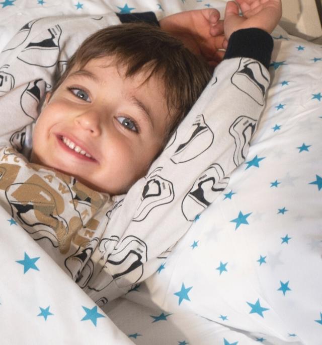 Smiling child stretching in bed